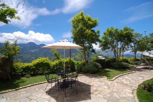 a patio with an umbrella and a table and chairs at Euro Country Villa in Renai