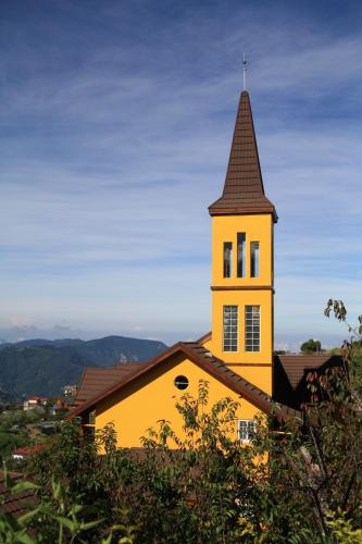 a yellow building with a tower on top of it at Euro Country Villa in Renai