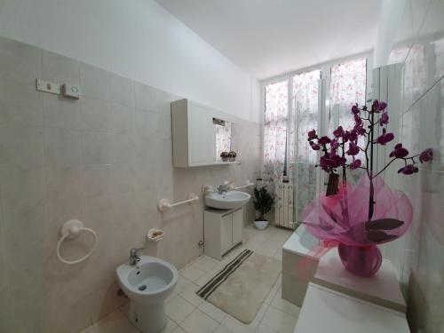 a bathroom with a toilet and a sink and a vase of flowers at Il Capriolo in Tavernelle