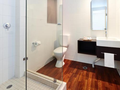 a bathroom with a toilet, sink, and shower at Hotel Urban St Leonards in Sydney