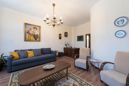 a living room with a blue couch and a table at LovelyStay - Heritage Collection House with 4Bedrooms in Porto