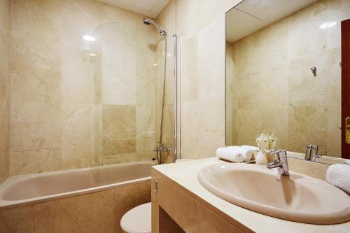 bagno con lavandino, vasca e servizi igienici di LEEWAYS LOFT V in GRAN VÍA a Madrid