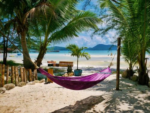 a woman laying in a hammock on a beach at Paradise Villas Koh Rong Sanloem in Koh Rong Sanloem