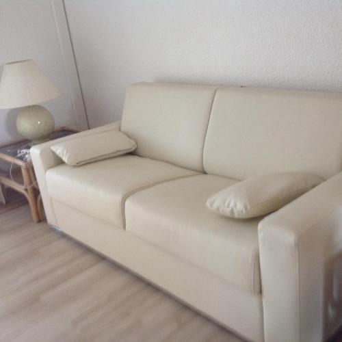 un sofá blanco en una sala de estar con lámpara en Cavalaire chez Michelle, en Cavalaire-sur-Mer