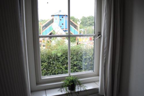 an open window with a view of a building at Groepsboerderij 20 pers. in Voorthuizen