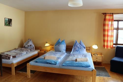 Chalupa Hojna Voda في Horní Stropnice: غرفة نوم بسريرين مع وسائد زرقاء