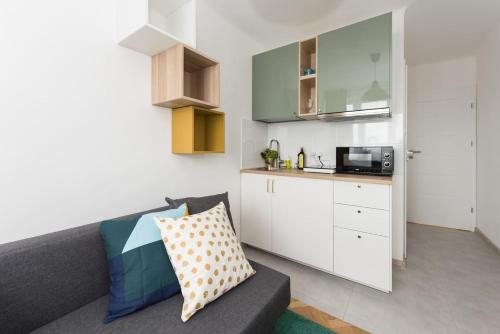 a living room with a couch and a kitchen at SuperApart Belwederska room B MiniStudio in Warsaw