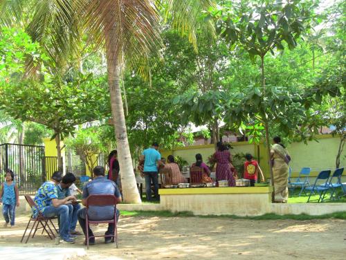 a group of people sitting in chairs in a park at Holiyday in VGF Farm House in Dānishpet