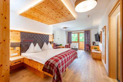 a bedroom with a bed with a red and white blanket at Hotel Lindenhof in Ramsau am Dachstein