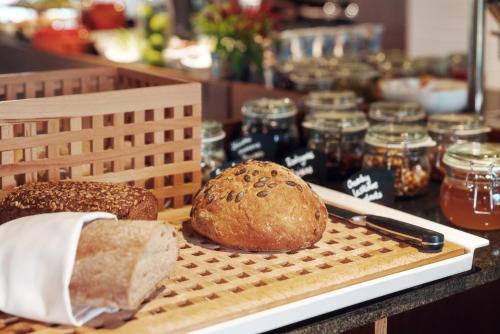 a loaf of bread on a cutting board with a loaf of bread at HOTEL ALMOND BUSINESS & SPA BY GRANO - GRANO HOTEL Gdańsk Riverside in Gdańsk