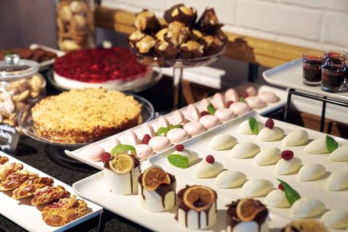a buffet filled with different types of food on a table at HOTEL ALMOND BUSINESS & SPA BY GRANO - GRANO HOTEL Gdańsk Riverside in Gdańsk