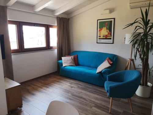 a living room with a blue couch and a chair at Apartment Sinčić in Novigrad Istria