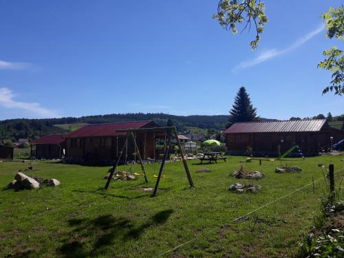 a park with a swing set in the grass at chalets les 5 loups in Gerbépal