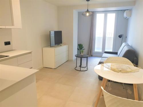 Il dispose d'une cuisine et d'un salon avec une télévision et une table. dans l'établissement Le studio terrasse proche mer 104, à Nice