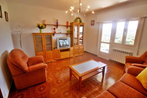 a living room with two chairs and a tv at Casa Ardaña in Carballo