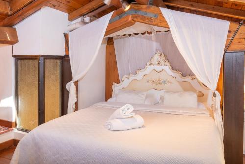 Un dormitorio con una cama blanca con una toalla. en Ca' Dinora Appartamenti, en Bardolino