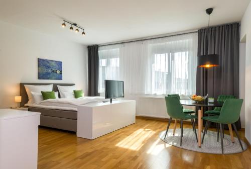 1 dormitorio con 1 cama, mesa y sillas en City Appartements Villach, en Villach