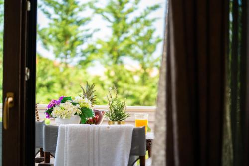 a table with chairs and flowers on a balcony at Fairytale Villa in Lefkada Town