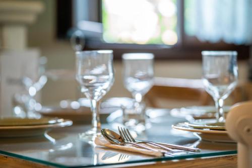 a table with glasses and plates and silverware on it at Fairytale Villa in Lefkada Town