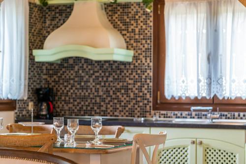 a kitchen with a table with wine glasses on it at Fairytale Villa in Lefkada Town