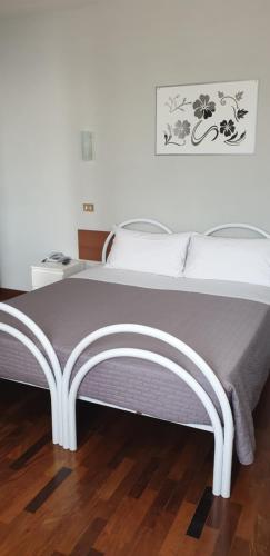 a large bed in a room with a wooden floor at Hotel Sporting in Campagnola Emilia
