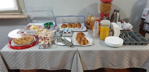 a table with plates of pastries and other food on it at Hotel Sporting in Campagnola Emilia