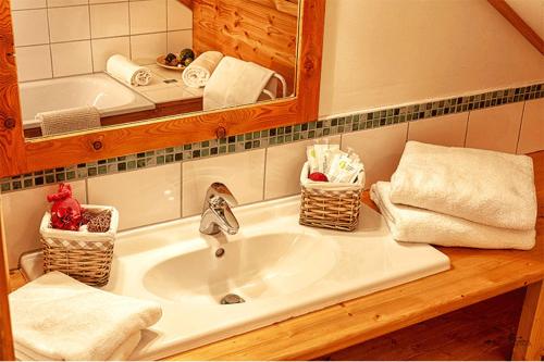 een badkamer met een wastafel, een spiegel en handdoeken bij Les Alisiers in Montclar