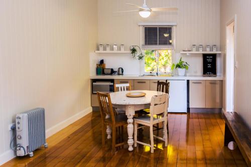 a kitchen with a table and chairs in a room at Kenilworth Cottage Barcaldine in Barcaldine