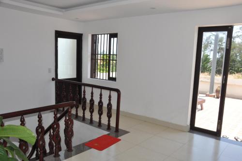 a room with a staircase and a door to a patio at Pearl Beach Homestay - Cua Dai Beach, Hoi An in Hoi An