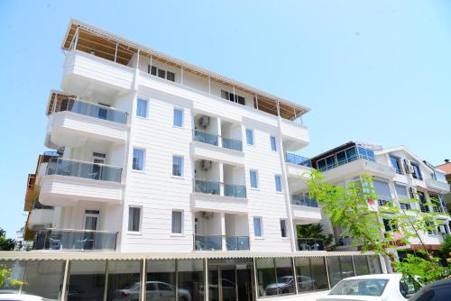 a white building with cars parked in front of it at Karden Otel in Antalya