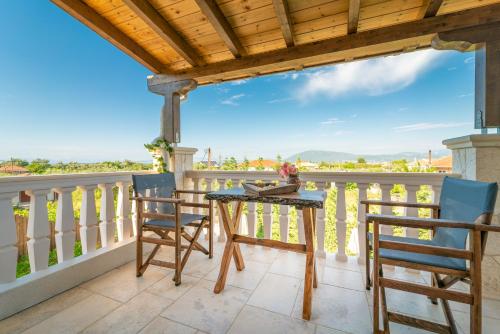 a patio with a table and chairs on a balcony at Fairytale Villa in Lefkada Town
