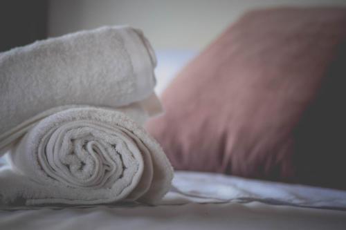 a roll of white towels sitting on a bed at DAHLIA Guesthouse in Koh Rong Sanloem