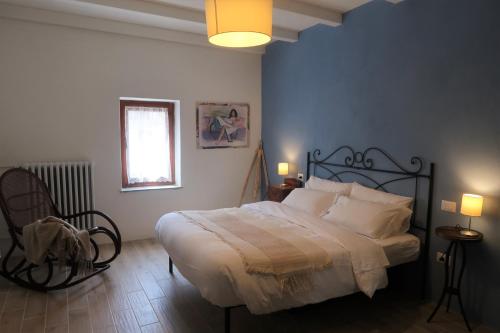 a bedroom with a large bed and a chair at La casa in collina in Bellagio
