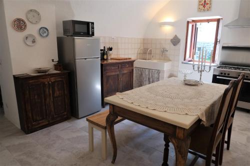 a kitchen with a table and a refrigerator at La casa in collina in Bellagio