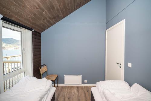 a room with two beds and a large window at Hemmingodden Lodge in Ballstad
