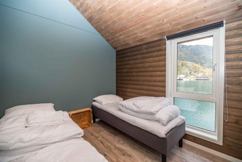 a bedroom with two beds and a window at Hemmingodden Lodge in Ballstad