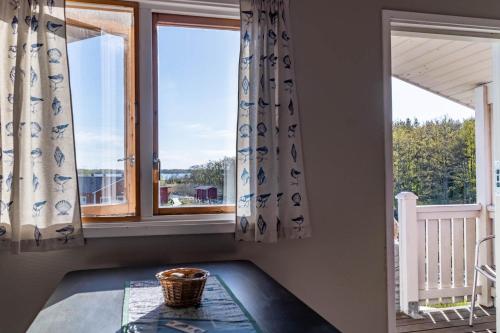 a room with two windows and a table in front at Kumlinge Stugor in Kumlinge