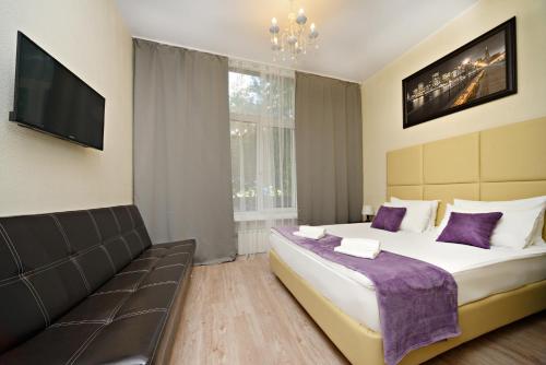 um quarto com uma cama grande e um sofá em Hotel Orange Leninsky Avenue em Moscou
