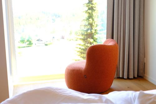 a orange chair sitting in front of a window at Fritz Lauterbad in Freudenstadt
