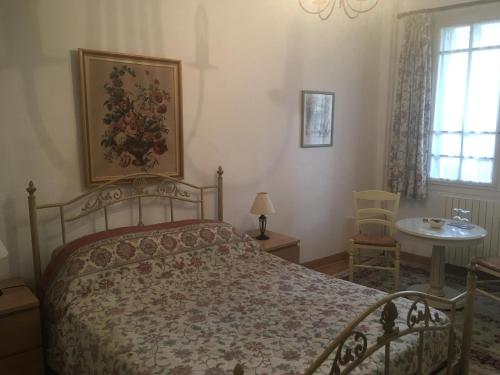 a bedroom with a bed and a table and a window at Poppys Chambres d'Hotes in Céret