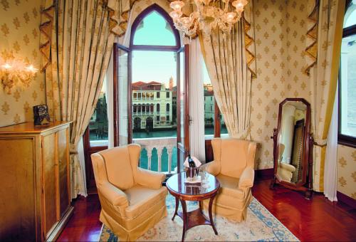 a living room with two chairs and a table and a window at Hotel Palazzo Stern in Venice