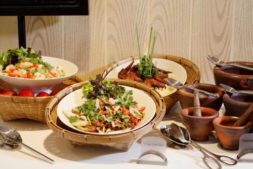 Una mesa con tres platos de comida encima. en The Quarter Hualamphong by UHG, en Bangkok