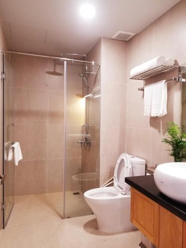 a bathroom with a shower and a toilet and a sink at Infinity Pool - 5 min walk to beach - Sekong Apartment in Danang