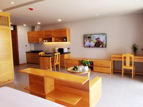 a kitchen with wooden cabinets and a dining room at Infinity Pool - 5 min walk to beach - Sekong Apartment in Da Nang