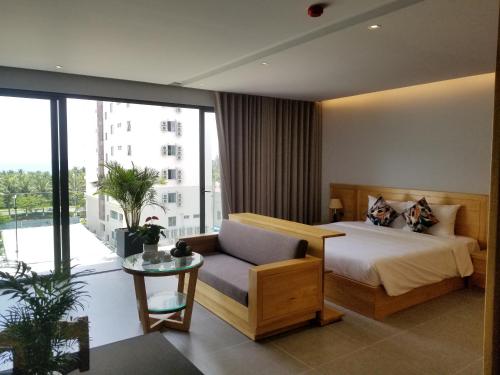 a bedroom with a bed and a couch and a window at Infinity Pool - 5 min walk to beach - Sekong Apartment in Da Nang