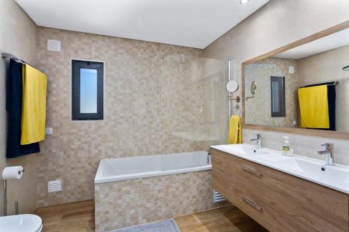 a bathroom with a tub and a sink and a toilet at Casa Saura in Alvor