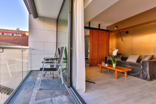 a balcony of a house with a couch and a table at Hotel Fagus by Aycon in Budva