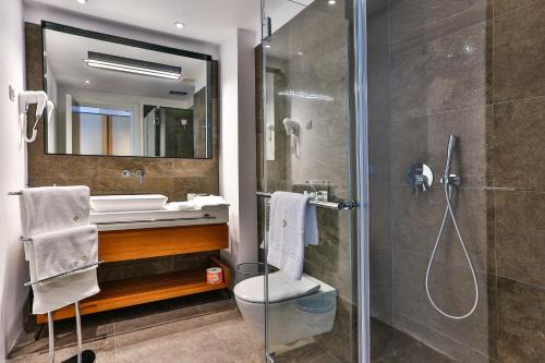 a bathroom with a shower, sink, and toilet at Hotel Fagus by Aycon in Budva