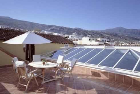 a patio with a table and chairs and a solar roof at Hotel Rural Victoria - La Orotava in La Orotava