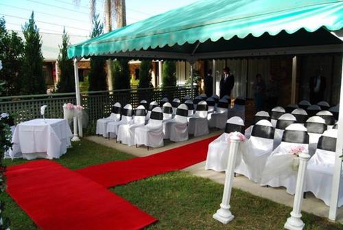 a group of white tables and chairs on a red carpet at Abcot Inn in Sylvania